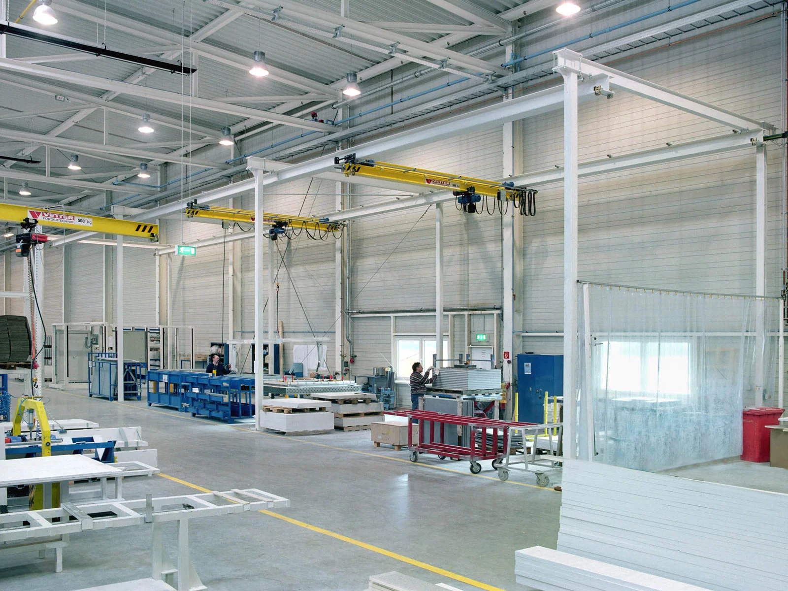 ZSP-M Portalkransystem mit weißen Stützen und gelben Brücken. Zwei Kranbrücken sind in einem gemeinsamen Portalsystem integriert.